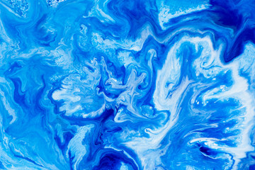 Classic blue and white watercolor paint in abstract striped swirling blurry shapes for design. An interesting unusual beautiful background in macro from streaks of spread mixed paint. Blurry paint.