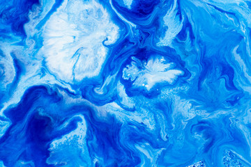 Classic blue and white watercolor paint in abstract striped swirling blurry shapes for design. An interesting unusual beautiful background in macro from streaks of spread mixed paint. Blurry paint.