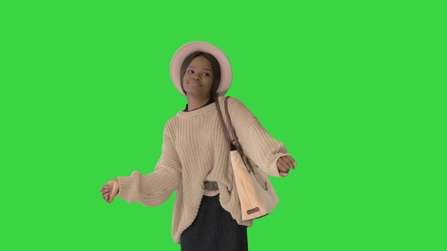 Stylish African American pretty young woman dancing on a Green Screen, Chroma Key.