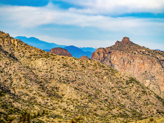 top of desert mountain with blue mountains in distance