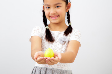 little child girl with easter bunny ears holding egg