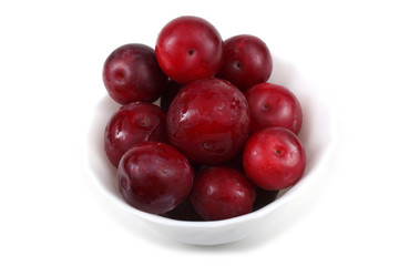 Red plums on dish