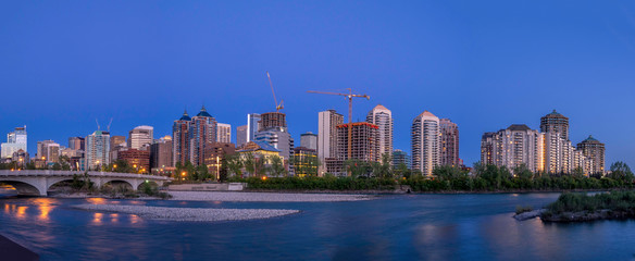 Calgary's skyline at dusk along the Bow River. Office and condominiums visible. 