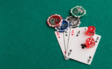 Poker chips, cards and dice on a green background. The concept of gambling and entertainment....