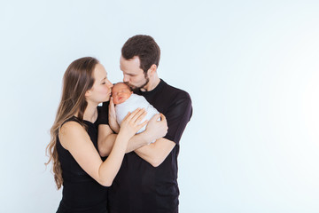 the concept of a healthy lifestyle, the protection of children, shopping - baby in the arms of the mother and father. Woman and man holding a child. Isolated on white background. Copy space