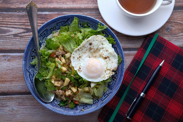 top view of salad , eggs on plate with notepad on table 