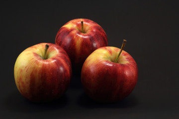 Three apples on black background