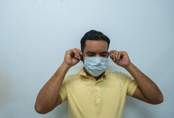 Man putting on a mask with a worried face. Virus concept