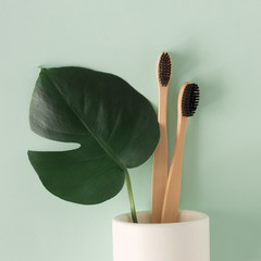 Zero waste concept. Top view natural eco bamboo toothbrush in stand on green background Flat lay