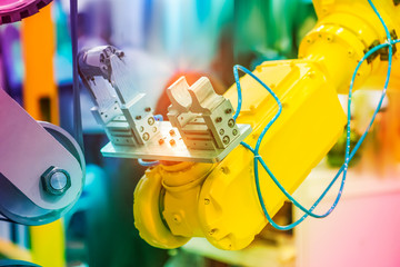 robotic arm handling the metal machined shaft parts polishing between the production line. automotive parts manufacturing process.