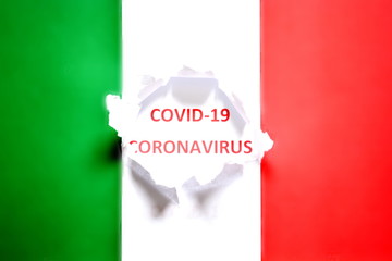 Background concept on virus coronavirus or covid-19 or 2019-ncov world outbreak from wuhan, china. Italian flag with hole in the paper