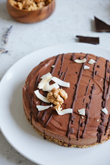 Homemade chocolate raw vegan cake - healthy dessert made from coconut milk, butter, cashew, cacao, walnut