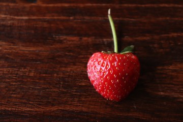 Red half strawberry on wood table for the seasonal fruit in winter