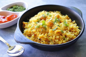 Indian comfort Food - Fresh Masala peanuts rice also known as Peanuts Pulav or rice khichdi. Garnished with coriander. Served hot with green chutney and mango pickle. with Copy space. 