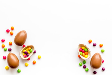 Fototapeta na wymiar Chocolate eggs - Easter symbol - frame on white background top-down copy space