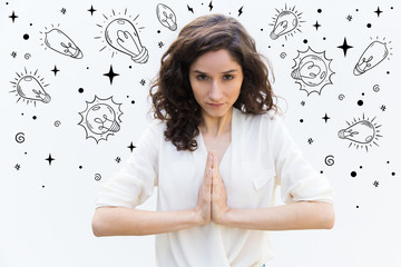 Focused young woman praying. Thoughtful lady with hands together in praying gesture. Hope and please concept