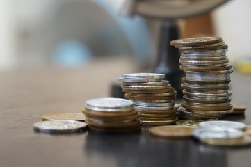 we have try keep collecting more money in order to travel and make a great journey for all around the world. many coins counted on the table with globe background for financial concept