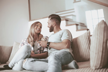 loving couple sitting on sofa in cozy living room