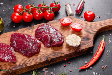 Fresh Raw Beef steak Mignon, with salt, peppercorns, thyme, tomatoes