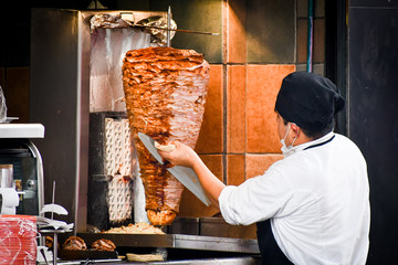 Taco maker cutting the pastor meat in Mexico City.