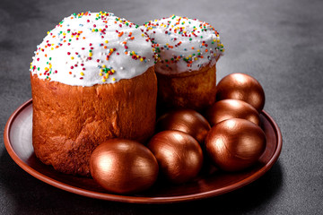 Easter eggs gold and bronze and Easter cake on a dark background