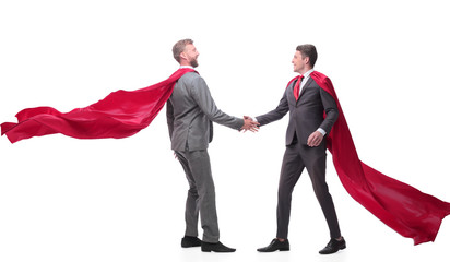 business partners in superhero cloaks shaking hands.