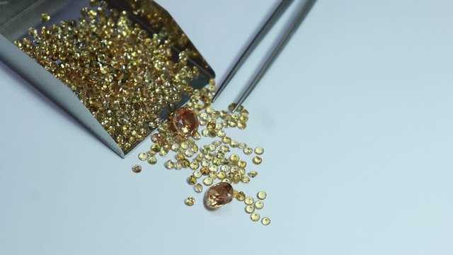 Shiny Yellow sapphires with and stainless steel Stone Shovel for Loose Stones. Top view on white background. Gemstone background.