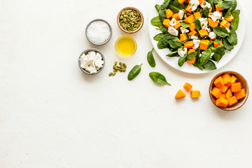 Cooking salad with pumpkin and basil. Ingredients on white background top-down copy space