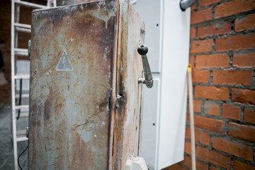 old rusty yellow electrical panel with hazard symbol