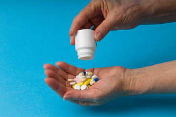 closeup woman hand holding medicine bottle taking overdose pills . Selective focus . motion blur .  Concept of dose of drugs, vitamins, coronavirus and flu treatment