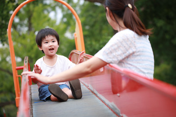 滑り台で遊ぶ親子
