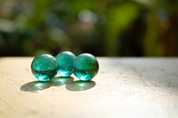 1. Three glass green marble ball on top and crystal clear with a nice shadow and good lighting with blur green background and text area space