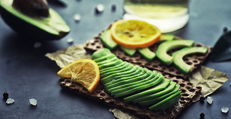 Avocado cooking recipes. Ripe green avocado on a wooden cutting board for serving.