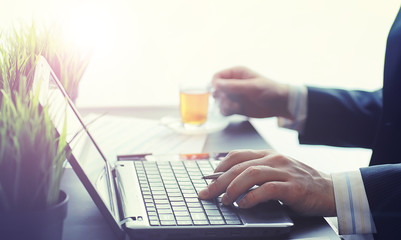 Businessman makes an online transaction. Trading on the exchange via the Internet. Manager works at a laptop in the office.