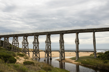 Obraz premium Gipplsand, Kilcunda Bourne Creek Trestle bridge on an overcast day with ocean in background.