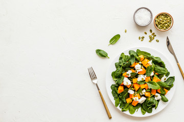 Healthy food concept. Salad with pumpkin and basil on white background top-down copy space