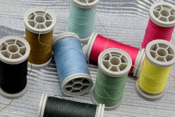 spools of thread on wooden background