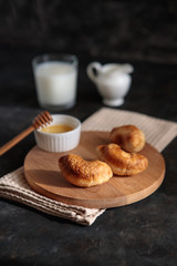 Croissants with honey and milk, close-up, on a dark background. French breakfast. Space for text. Dessert