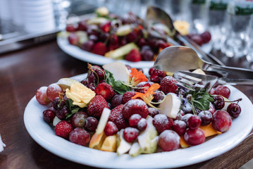 Plate with fruits and berries on servered buffet table at luxury wedding reception outdoors. Catering banquet table in restaurant. Restaurant presentation, food, party concept.