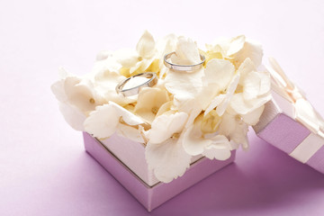 Box with beautiful wedding rings on color background
