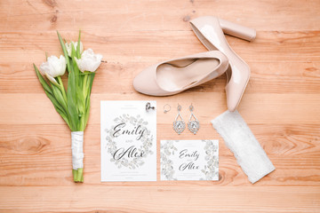 Beautiful composition with wedding invitations and jewelry on wooden background