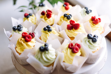 Vanilla cupcakes with cream cheese frosting and fresh blueberries and raspberries.
