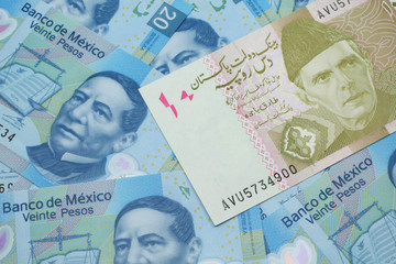 Fototapeta premium A close up image of a gray and pink twenty Pakistani rupee bank note with Mexican twenty peso bank notes in macro