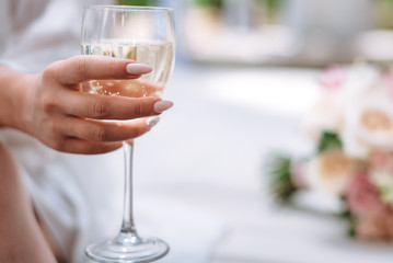 a glass of champagne in the hands of the bride