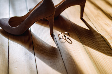 Silver shoes and rings, composition isolated on the wooden floor. Accessory bride. Footwear....