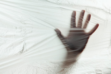 Human hand on background of plastic trash polluting planet. Stop the use of plastic packaging and bags.