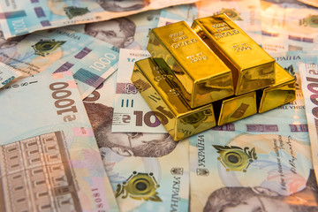 Gold bars on new banknote of Ukraine 1000 ad background. Save and money concept.
