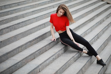 A girl posing on the steps of a building