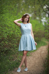 Naklejka na ściany i meble Girl in blue dress in green park