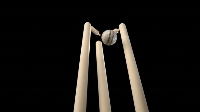 Cricket ball hitting stumps in ultra slow motion . Bales flying off . Batsman out . | Includes alpha matte